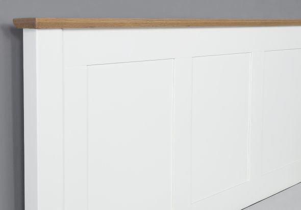 Classic style white painted wooden bed frame with a solid light oak headboard plinth. Low foot end. Panelled headboard.